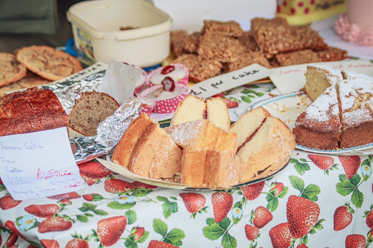 Home A variety of homemade cakes on a colorful table at a market stall.